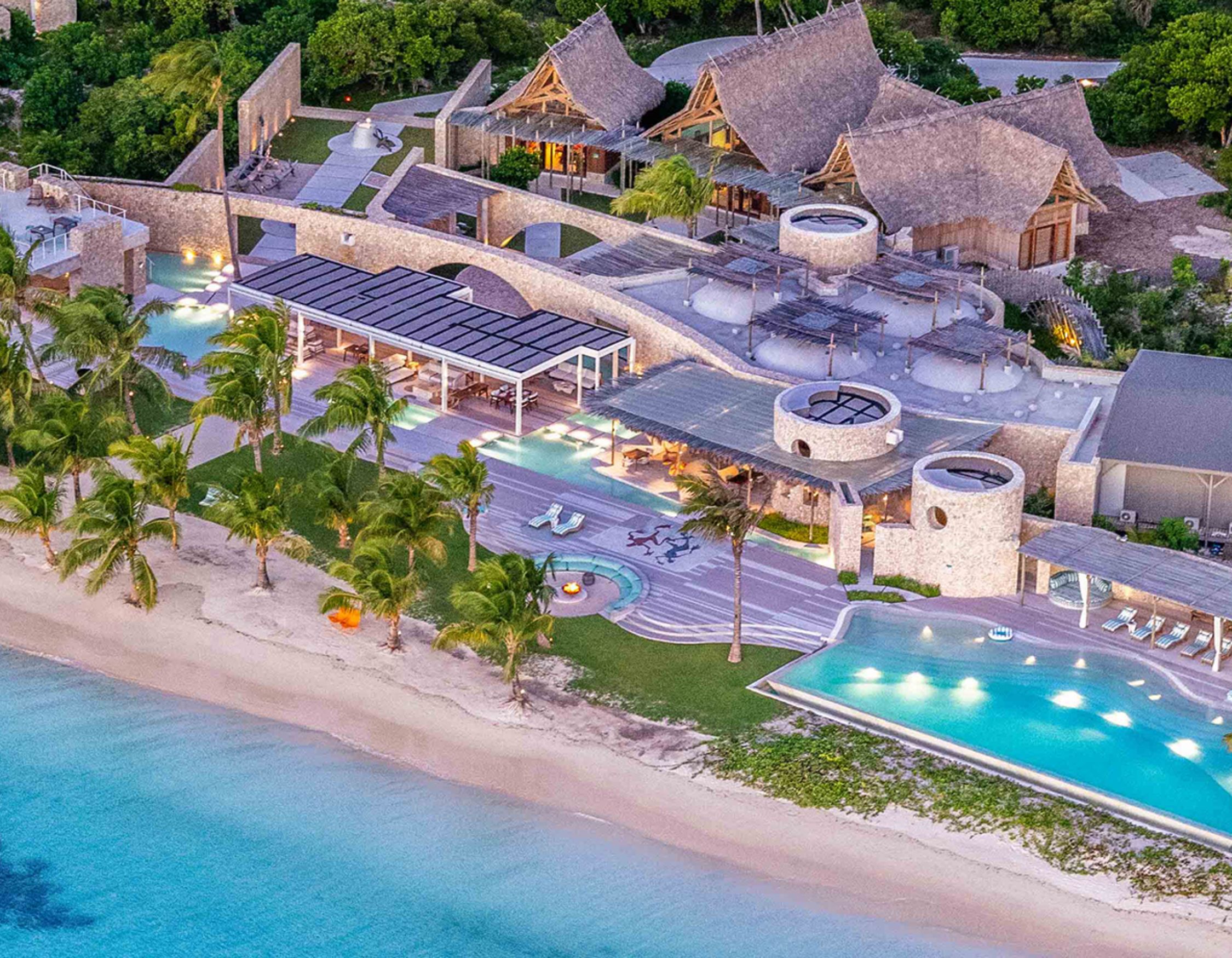 Aerial dusk view of a private island resort's pools and thatched architecture, Madagascar