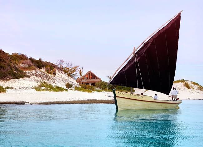 A traditional dhow under full sail approaching the shore at Benguerra Island, Bazaruto Archipelago