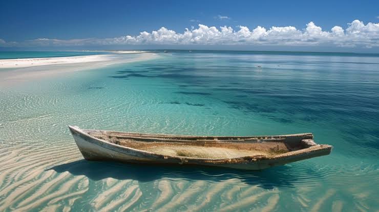 A weathered wooden dhow resting on a tidal sandbank in the shallows off Benguerra Island