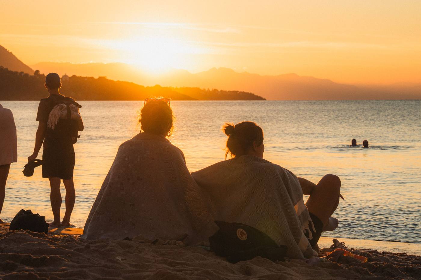 Visitors relaxing on a Lake Malawi beach at sunset, part of an all-inclusive African safari itinerary