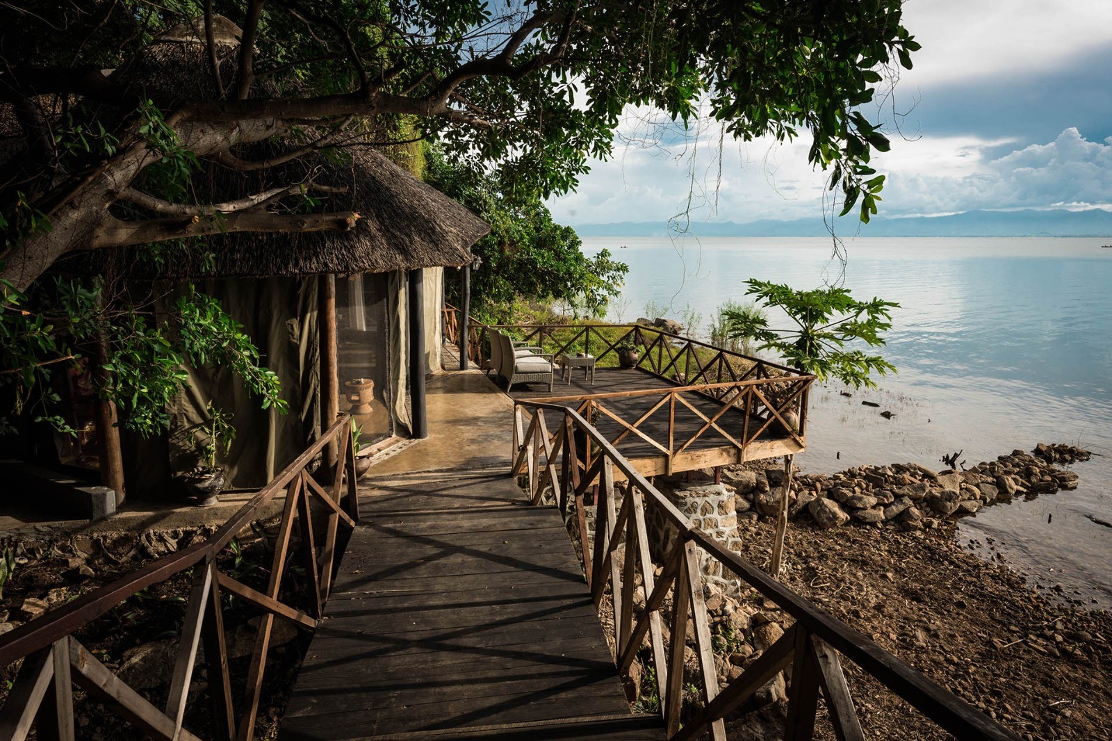 A stone-and-thatch cottage built into granite boulders on the shore of Lake Malawi