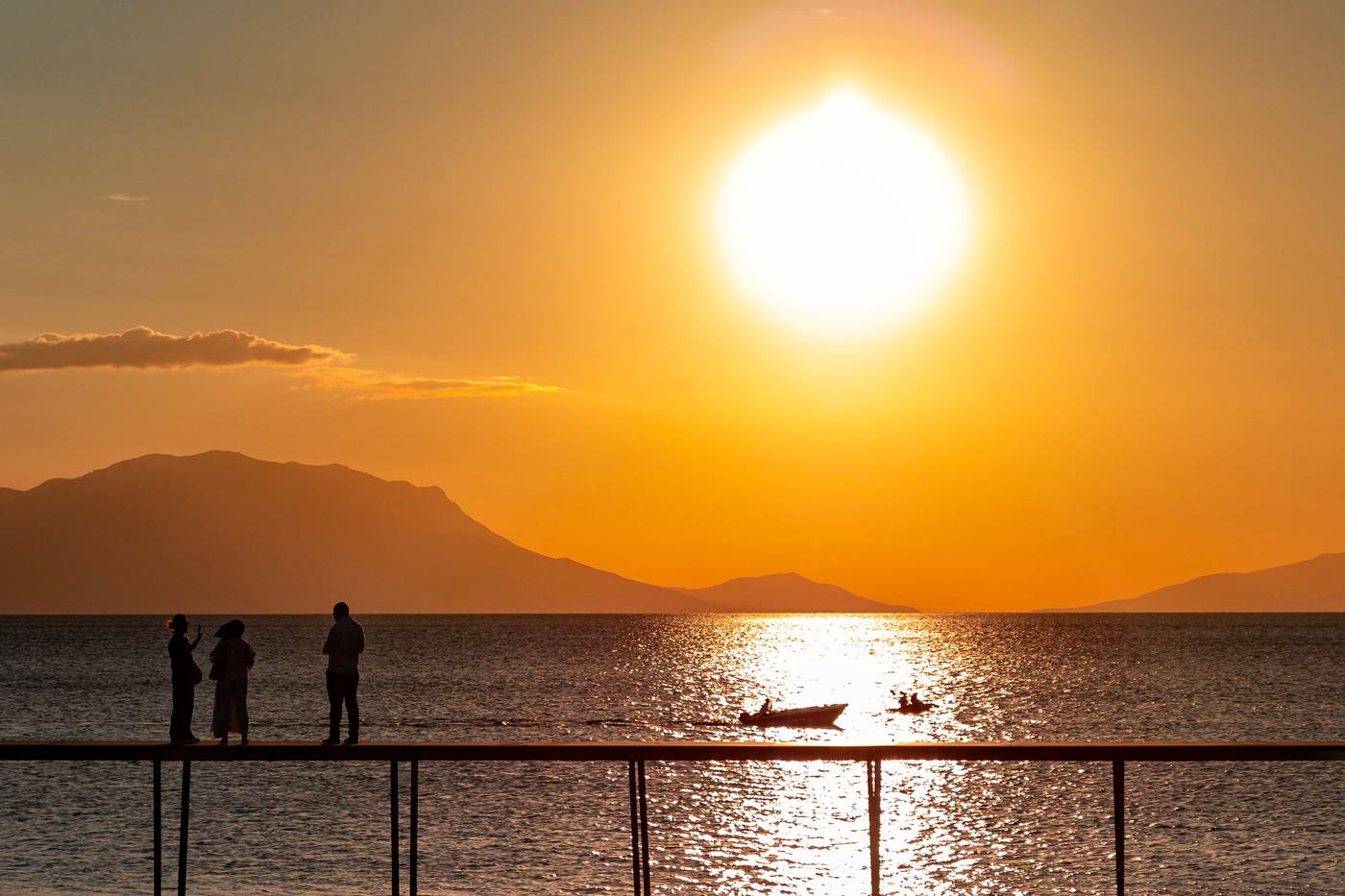 Visitors watching the sunset from a lakeside pier on Lake Malawi's private safari extension